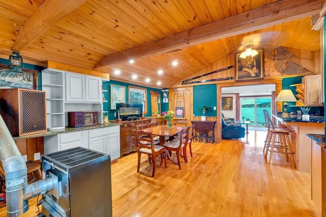 a dining hall with couches a dining table and chairs with wooden floor