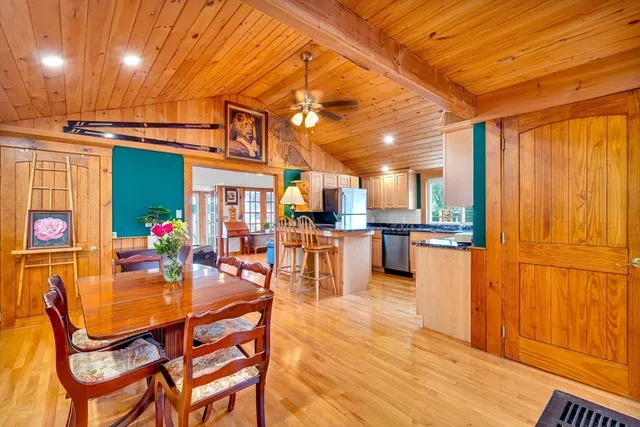 a dining room with stainless steel appliances kitchen island granite countertop a table and chairs
