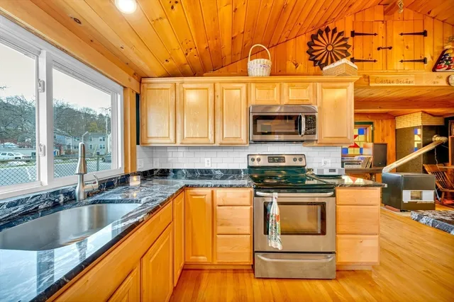 a kitchen with stainless steel appliances granite countertop a stove a sink and a microwave