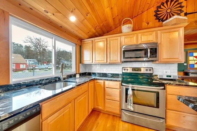 a kitchen with stainless steel appliances granite countertop a stove a sink and a microwave