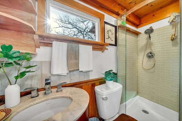 a bathroom with a sink a toilet and shower