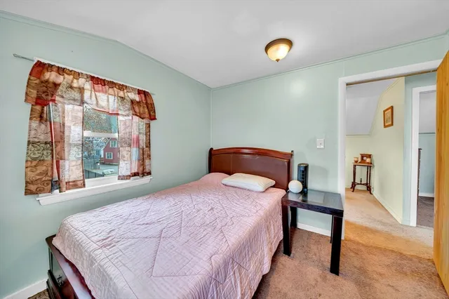 a bedroom with a bed and a lamp next to a window