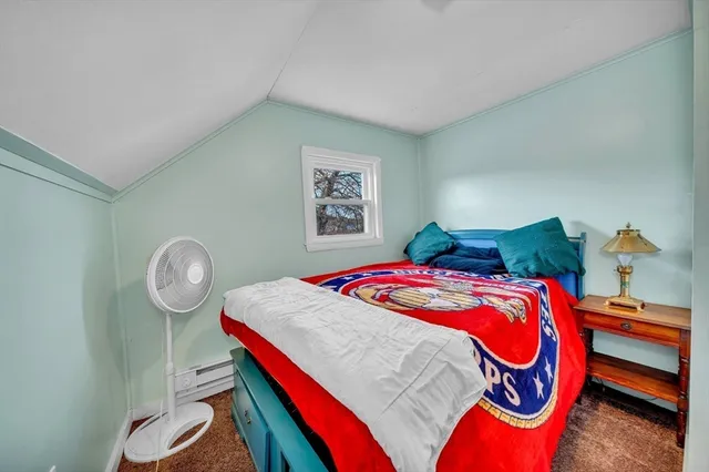 a bedroom with a bed and a lamp on dresser