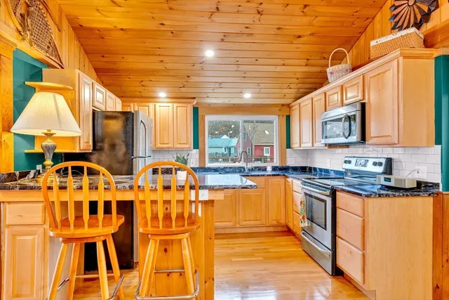 a kitchen with stainless steel appliances granite countertop a stove and cabinets