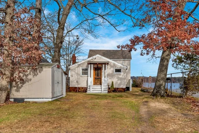 a white house that has a tree in front of it