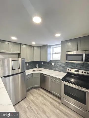 a kitchen with stainless steel appliances granite countertop a refrigerator and a stove top oven