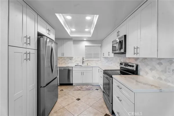 a kitchen with a refrigerator sink and cabinets