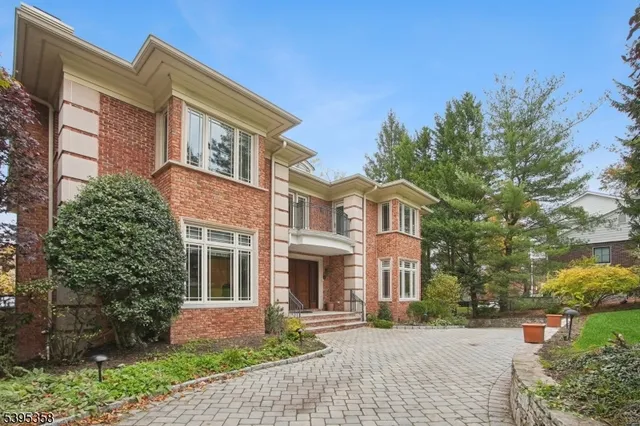 a front view of a house with a yard and trees