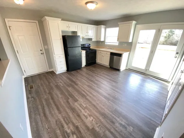 a view of a kitchen with wooden floor and a refrigerator