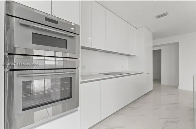 a kitchen with white cabinets and stainless steel appliances