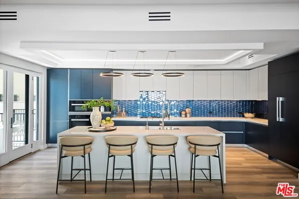 a kitchen with a dining table chairs and wooden floor