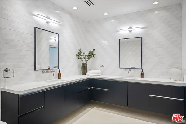 a bathroom with a double vanity sink mirror and
