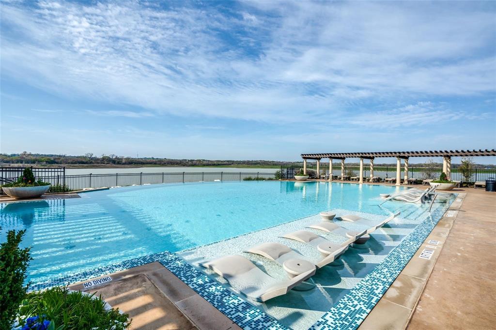 1205 Ivy Charm Way Arlington, TX 76005 - Photo 36 of 40 Infinity-edge pool with underwater loungers, integrated spa, and a poolside pergola structure, all overlooking a substantial body of water