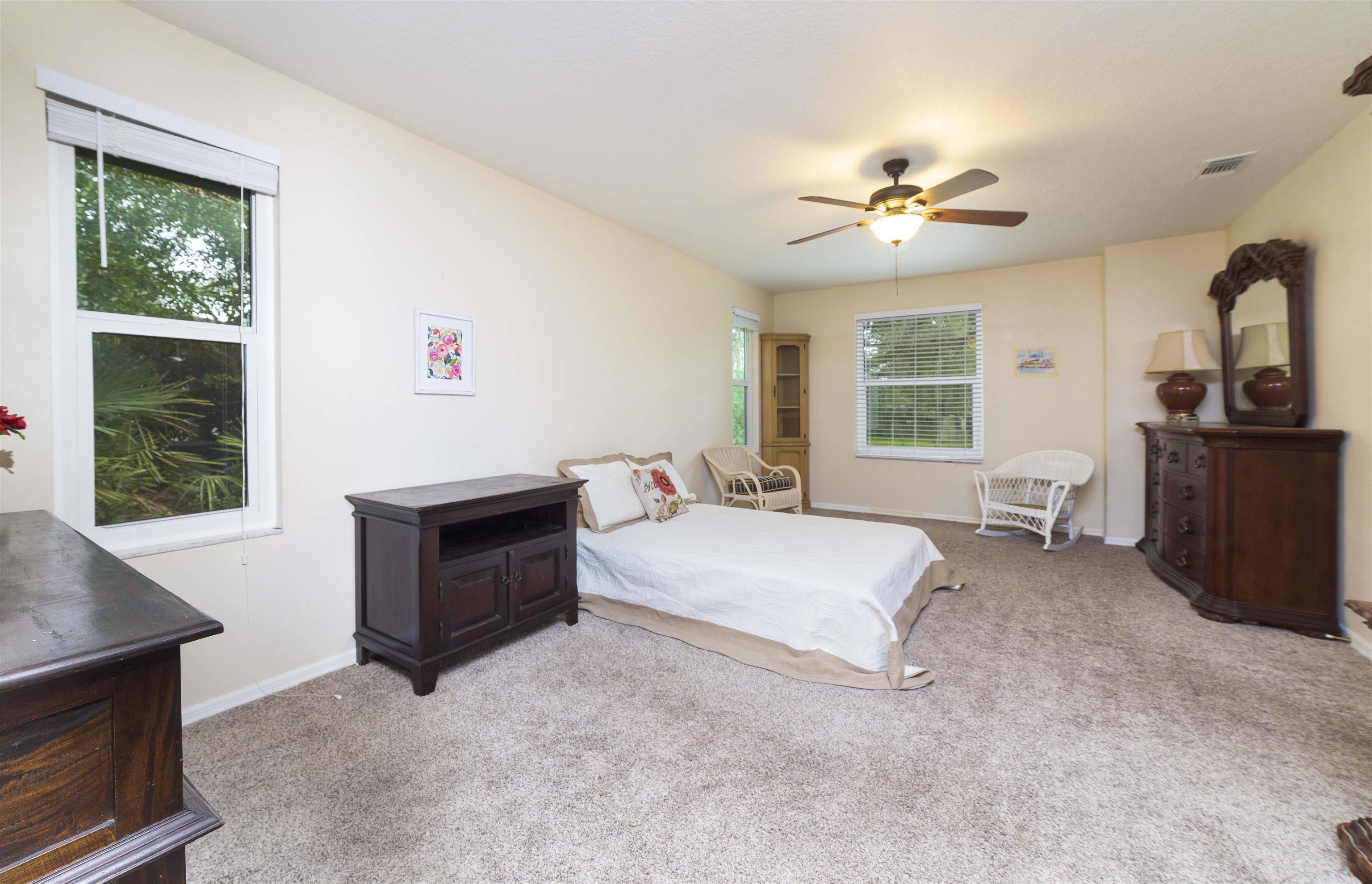 208 Jasmine Road St. Augustine, FL 32086 - Photo 17 of 34 a spacious bedroom with a bed dresser and a window