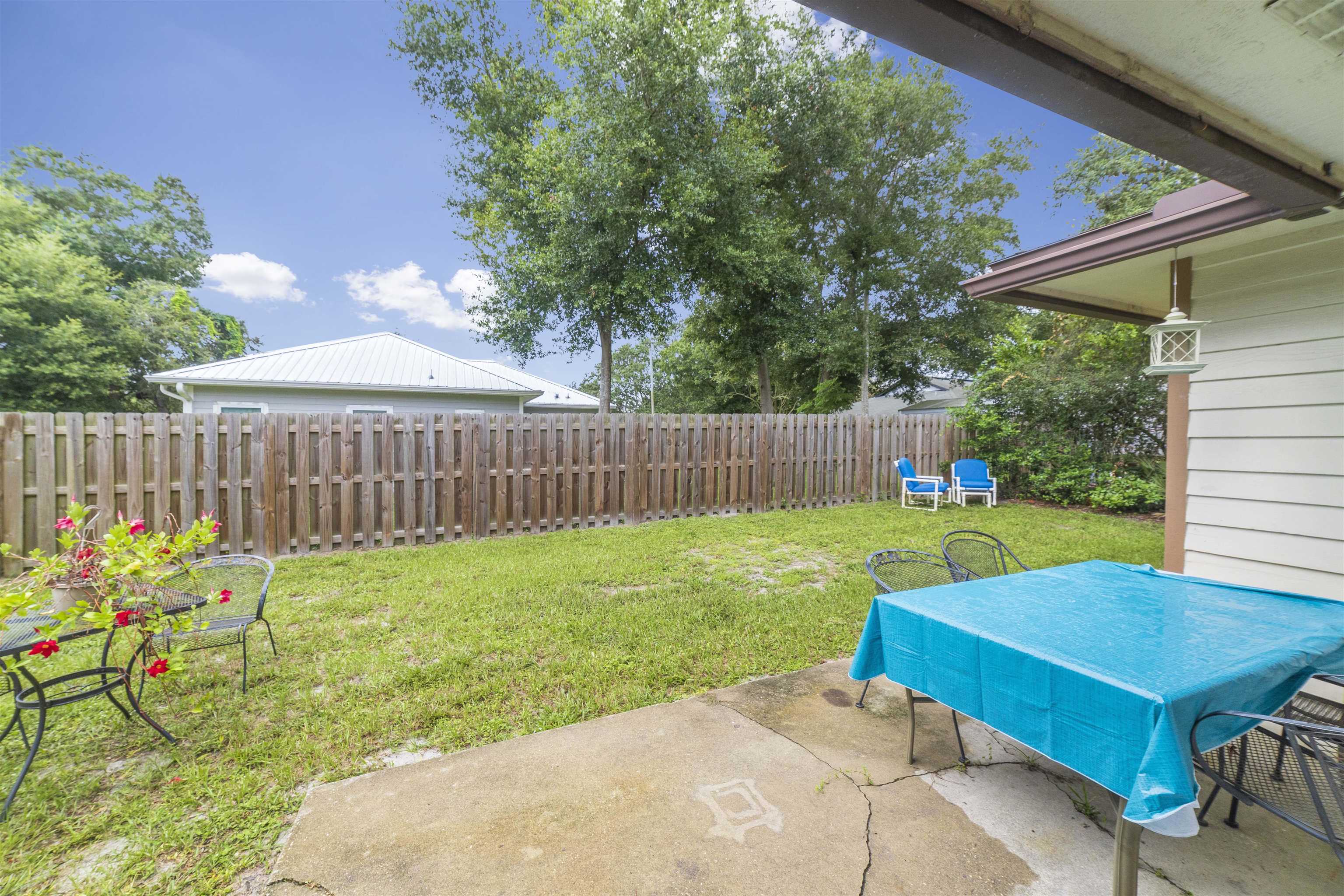 208 Jasmine Road St. Augustine, FL 32086 - Photo 33 of 34 a view of a backyard with table and chairs and wooden fence