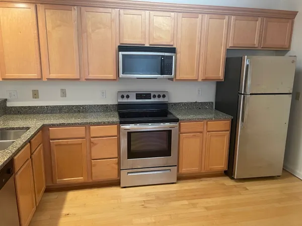 a kitchen with granite countertop a refrigerator stove and microwave