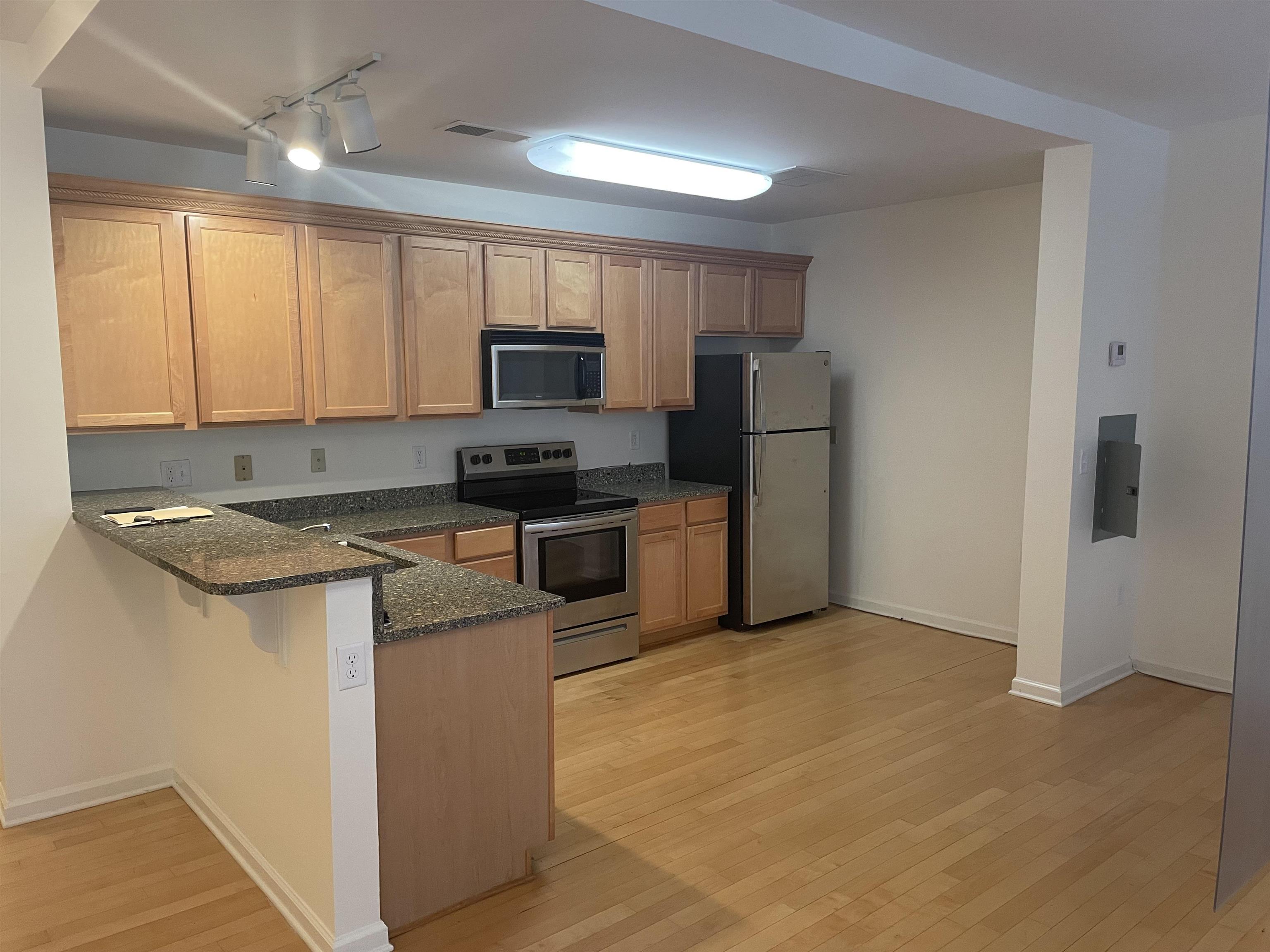 720 Litty Court, Unit 102 Memphis, TN 38103 - Photo 14 of 20 a kitchen with stainless steel appliances granite countertop a stove a sink a refrigerator and a microwave