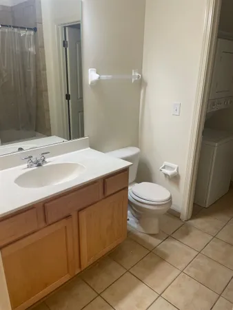 a bathroom with a sink a toilet a mirror and shower