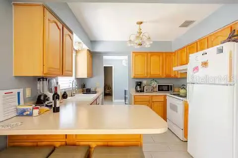 a kitchen with stainless steel appliances granite countertop a sink dishwasher stove and refrigerator with wooden floor