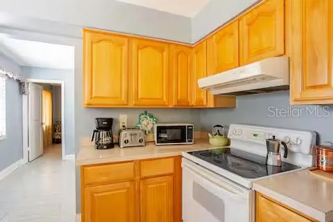 a kitchen with stainless steel appliances granite countertop a sink a refrigerator and cabinets