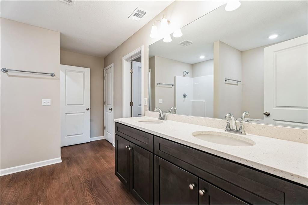 23 Whiterock Road Phenix City, AL 36869 - Photo 19 of 29 Bathroom with walk in shower, wood finished floors, a sink, and visible vents