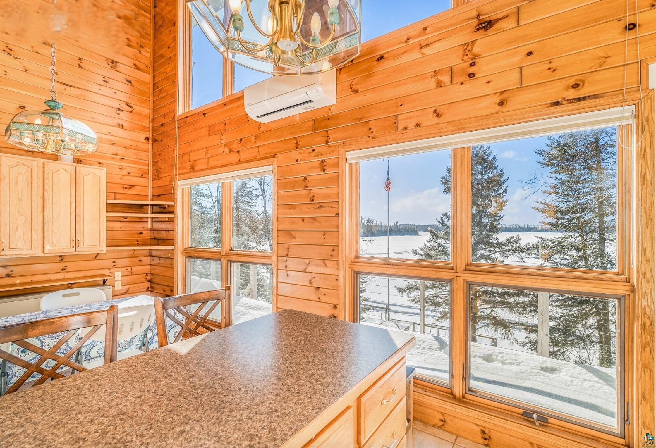 1480 Devil Track Road Grand Marais, MN 55604 - Photo 13 of 38 Kitchen featuring wooden walls, light wood finish cabinets, hanging lights, and a high ceiling