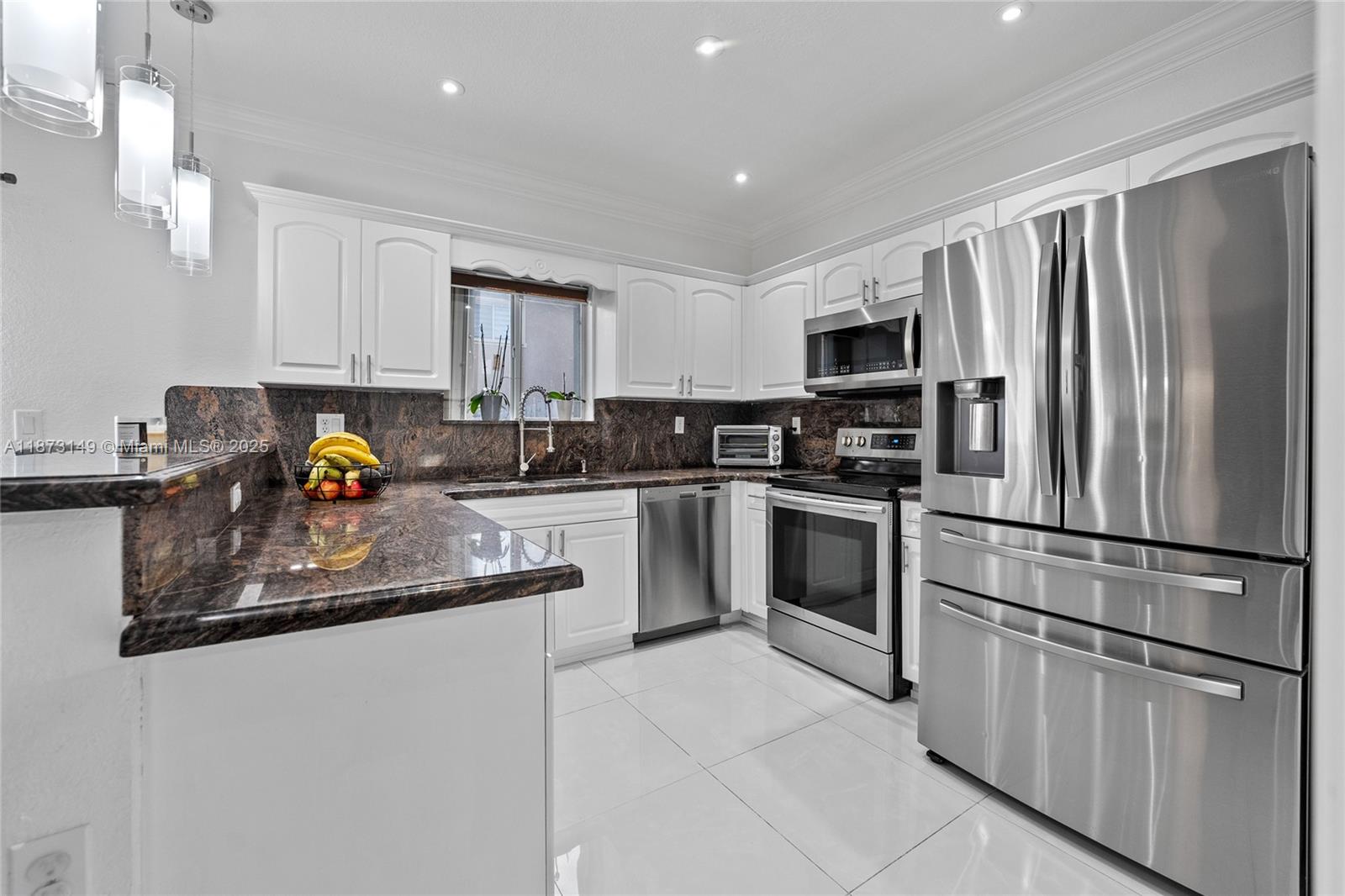 21474 Southwest 85th Path Cutler Bay, FL 33189 - Photo 12 of 30 a kitchen with stainless steel appliances granite countertop a refrigerator sink stove microwave and cabinets