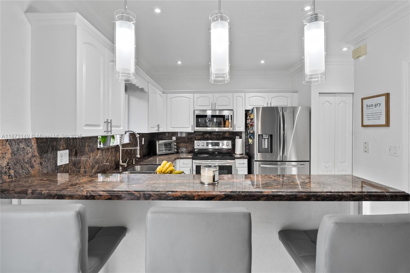21474 Southwest 85th Path Cutler Bay, FL 33189 - Photo 13 of 30 a kitchen with stainless steel appliances granite countertop a sink refrigerator and cabinets