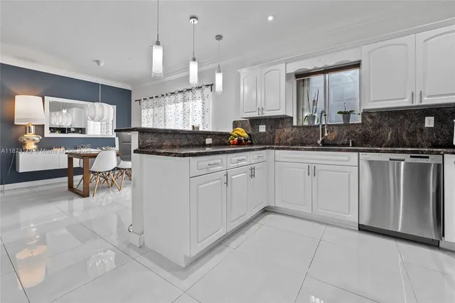 a kitchen with white cabinets and sink