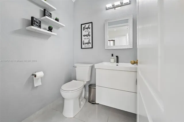 a white toilet sitting next to a bathroom sink
