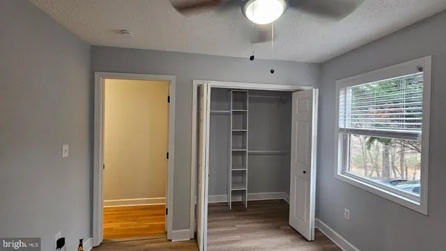 a view of empty room with window and cabinet