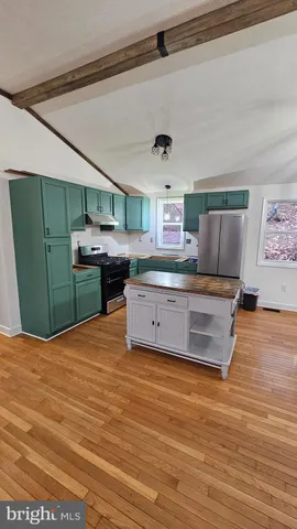 a kitchen with stainless steel appliances a stove and cabinets