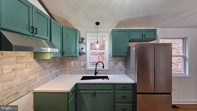 a kitchen with a refrigerator sink and cabinets
