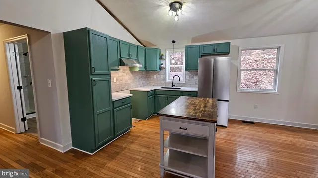 a kitchen with stainless steel appliances granite countertop a refrigerator and a sink