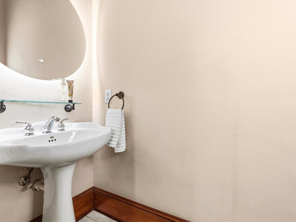 1615 Roma Lane Allen, TX 75013 - Photo 18 of 36 Half Bath with pedestal sink with chrome faucet, circular mirror, and glass shelf