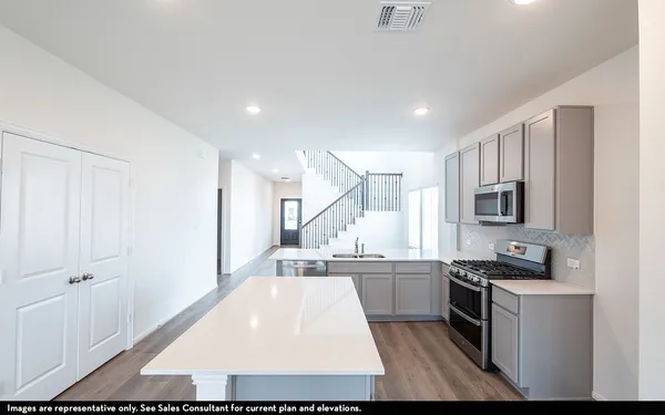 a large kitchen with stainless steel appliances kitchen island granite countertop a sink and cabinets