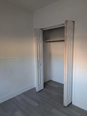 an empty room with wooden floor and a door
