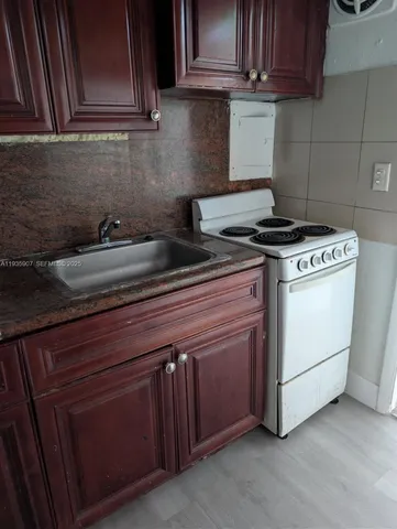 a kitchen with granite countertop cabinets stainless steel appliances and a sink