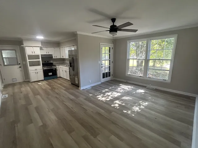 a view of a livingroom with wooden floor and window