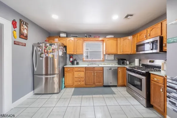 a kitchen with stainless steel appliances granite countertop a refrigerator and a sink