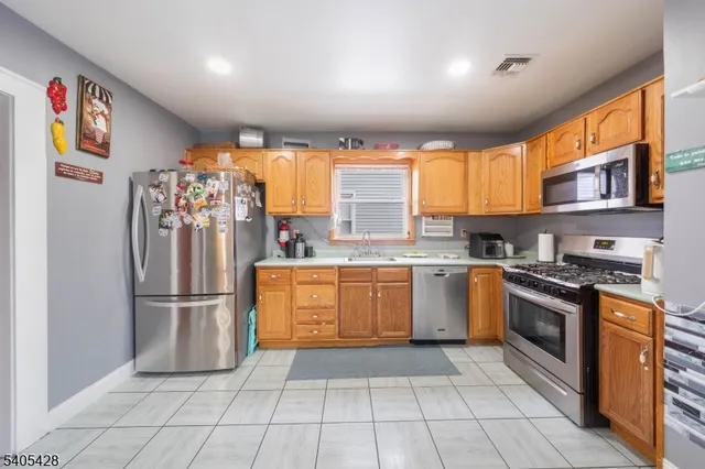 a kitchen with stainless steel appliances granite countertop a refrigerator and a sink