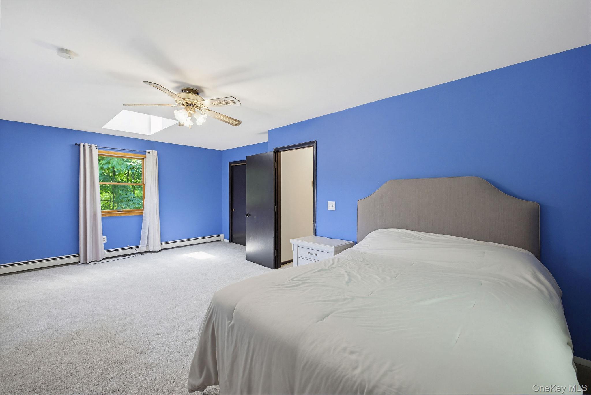 12 Bradhurst Road Carmel, NY 10512 - Photo 23 of 28 a bedroom with a bed and a chandelier