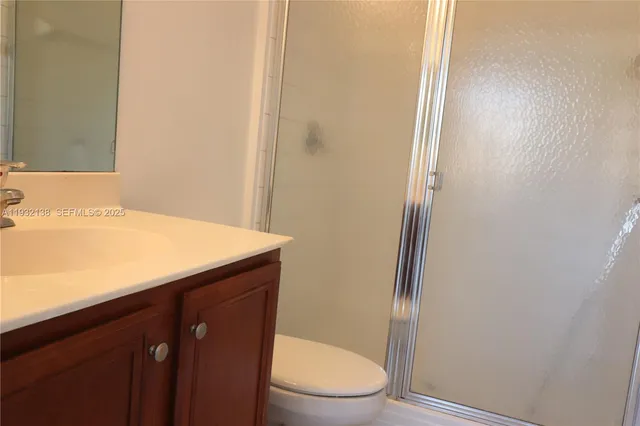 a bathroom with a granite countertop toilet and a sink