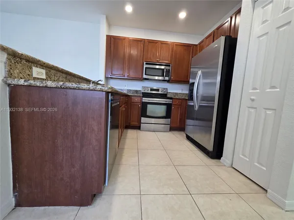 a view of kitchen and refrigerator
