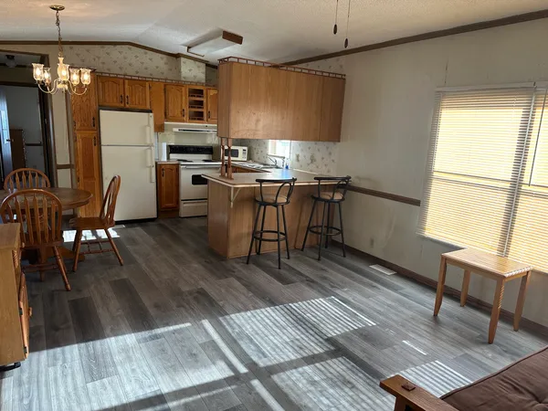 a kitchen with a table chairs refrigerator and cabinets