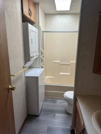 a bathroom with a sink a toilet and shower