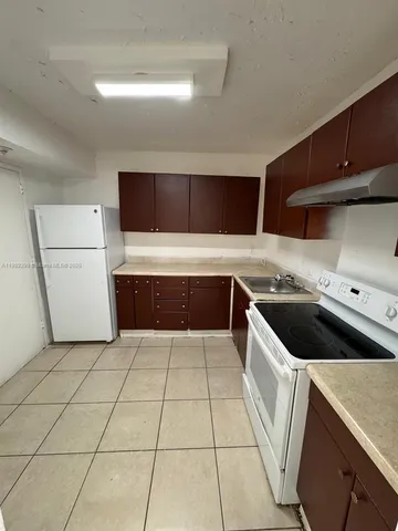 a kitchen with a cabinets and white stove top oven