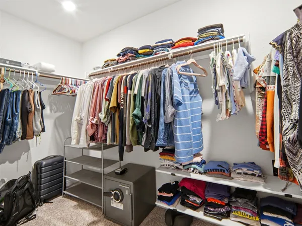 a view of walk in closet with clothes and shoes