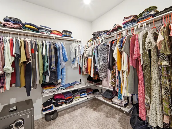 a view of walk in closet with clothes