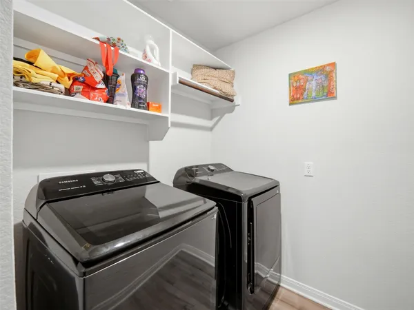 a utility room with dryer and wall